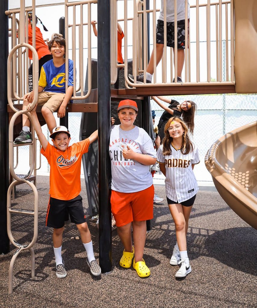 Students playing on the playground climbing structure