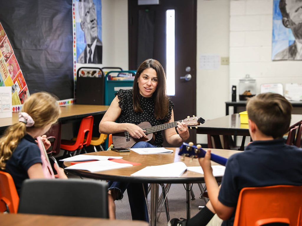 Teacher playing ukulele for her students in the classroom