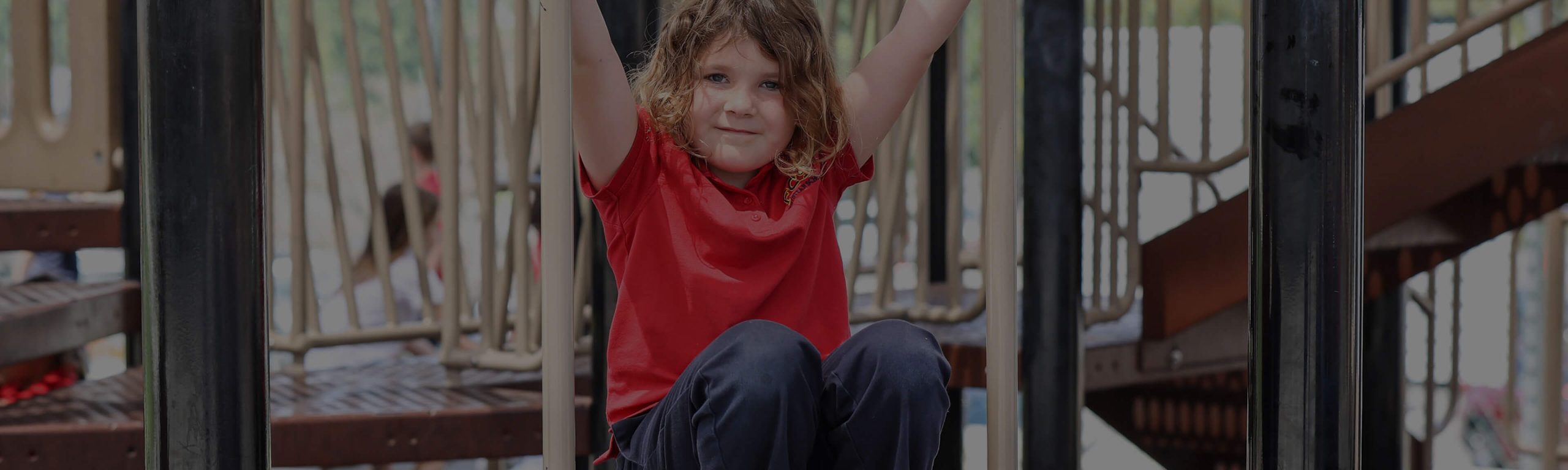 Kindergartener in a red shirt playing on the playground