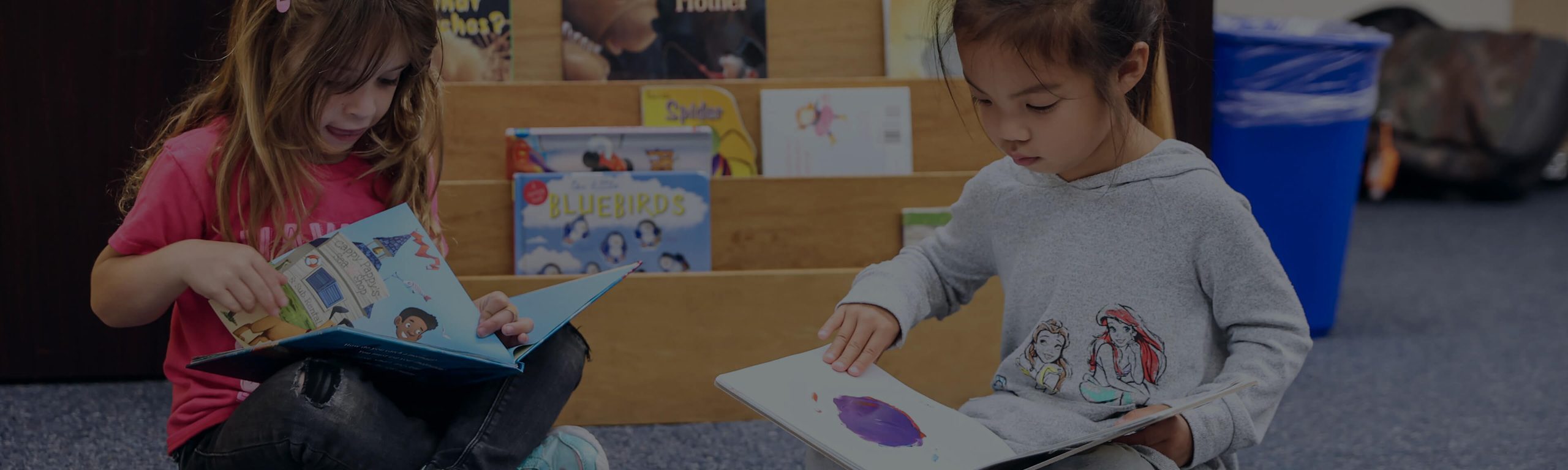 Preschool girls looking at picture books in the classroom