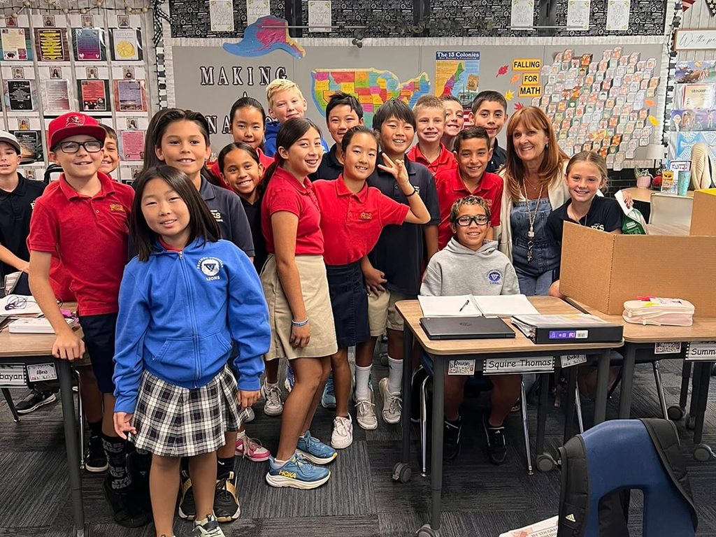 Elementary class in uniforms posing together in their classroom