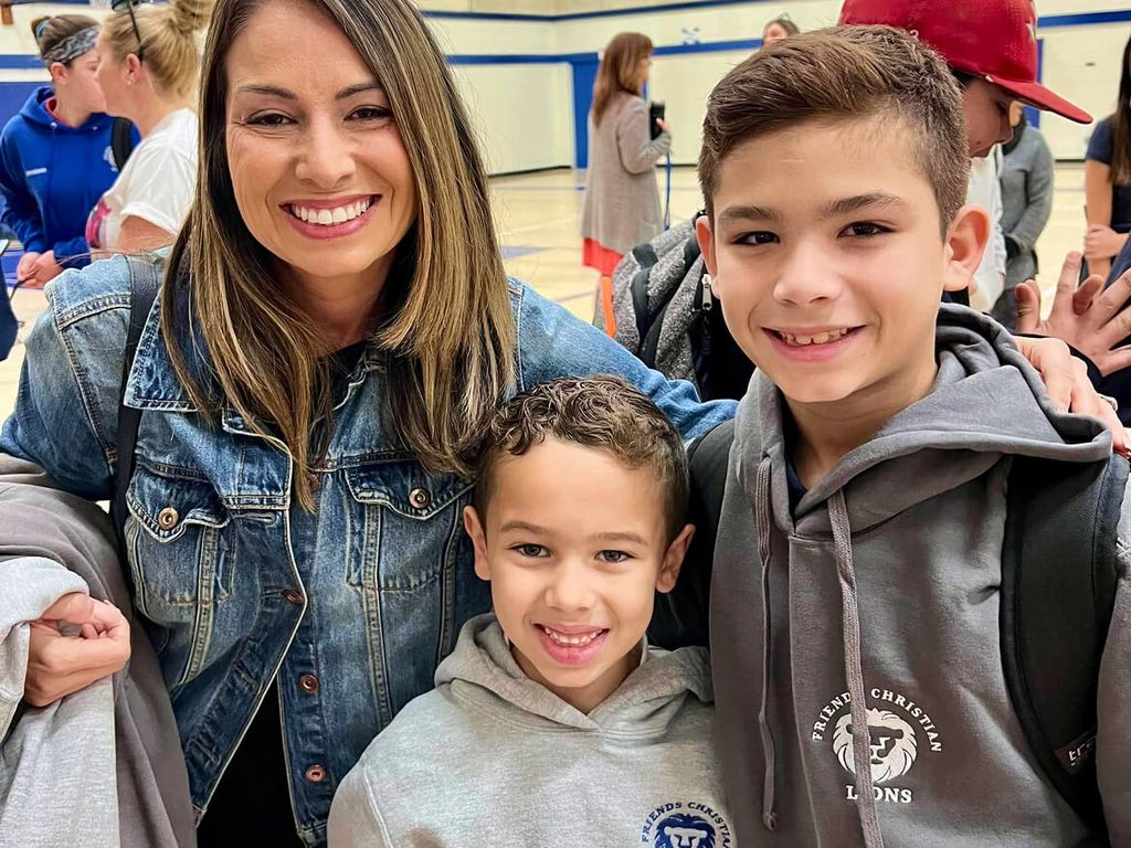 Smiling mother with her two sons at a school event