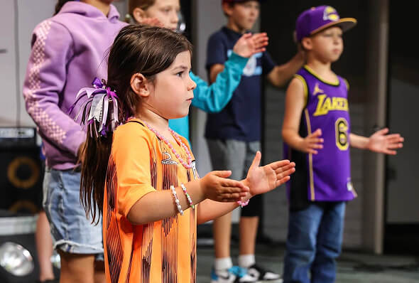 Young students singing and clapping during a chapel worship time